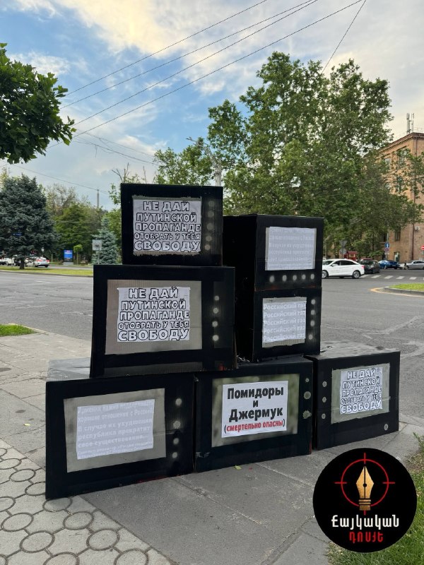Инсталляция в Ереване с горой картонных телевизоров и окровавленной пешкой, выражающая протест против пропаганды.