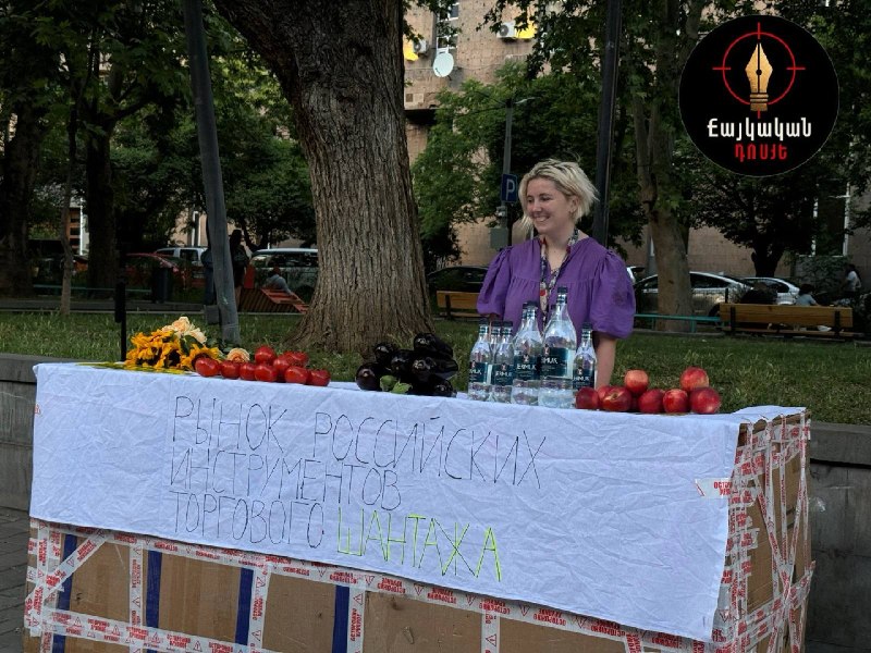 Ироничная инсталляция на Вернисаже в Ереване с плакатами о российском торговом шантаже, помидорами и водой Джермук
